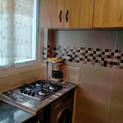 a kitchen with a stove top oven next to a window at Apartment with Elevator Stadium and CHU within walking distance in Fès