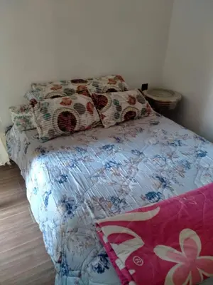 a bedroom with a bed with a floral bedspread and pillows at Apartment with Elevator Stadium and CHU within walking distance in Fès