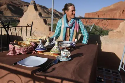 a man sitting at a table with teapees on it at KASBAH DES MONTAGNS maisons d'hôtes la vallée des roses in Bou Tharar