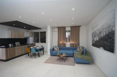 a living room with a blue couch and a kitchen at Luxury Fes Residence Appartement & Studio in Fès