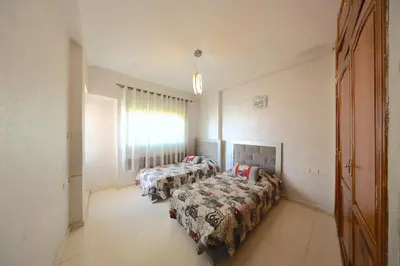 a bedroom with two beds and a window at Apparemment de vacances centre de fes in Fès