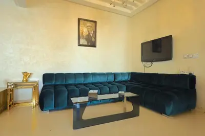 a blue couch in a living room with a tv at Apparemment de vacances centre de fes in Fès