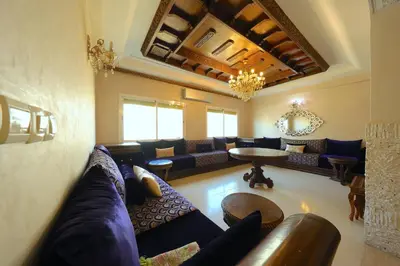 a large living room with blue couches and a table at Apparemment de vacances centre de fes in Fès
