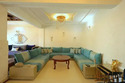 a living room with a blue couch and a table at Apparemment de vacances centre de fes in Fès