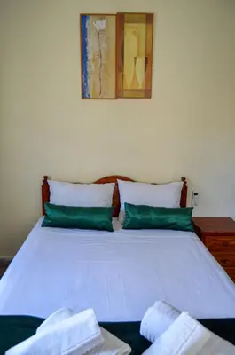 a bed with green pillows and a picture on the wall at dar sara medina fes in Fès