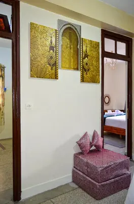 a room with a couch and paintings on the wall at dar sara medina fes in Fès