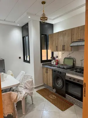 a kitchen with a stove and a sink and a table at Dar aya in Beni Mellal