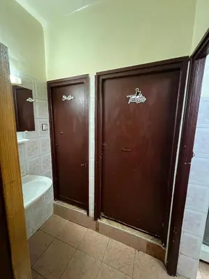 a bathroom with two brown doors and a toilet at Appartement Old Medina fes in Fès