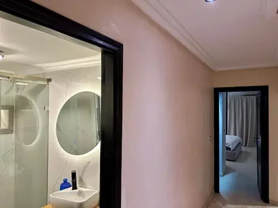 a bathroom with a shower and a sink and a mirror at Les Palmiers de l ile Jacob in Fès