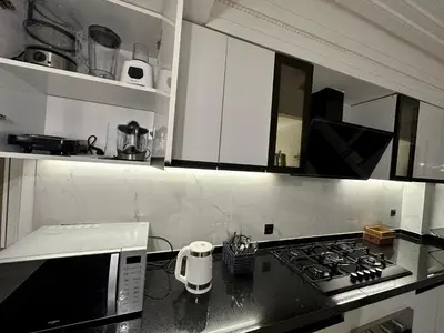 a kitchen with white cabinets and a stove top oven at Les Palmiers de l ile Jacob in Fès