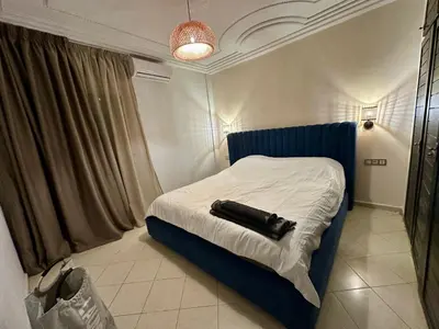 a room with a bed with a black object on it at Les Palmiers de l ile Jacob in Fès