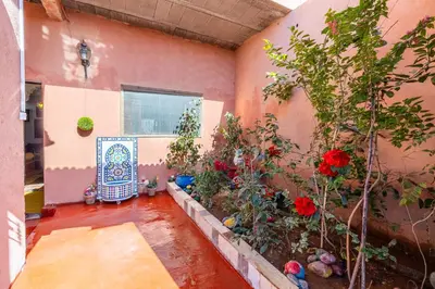 a room with flowers and a window and a chair at Atlas Suite Riad 3 Bedrooms near Marrakech in Tikoutar