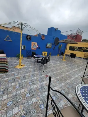 a blue building with a patio with chairs and a table at Dar KAYED in Fès