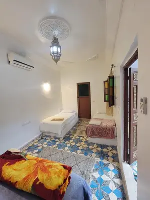 a room with two beds and a floor at Dar KAYED in Fès