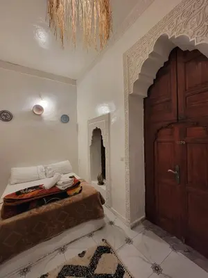 a bedroom with a bed and a wooden door at Dar KAYED in Fès