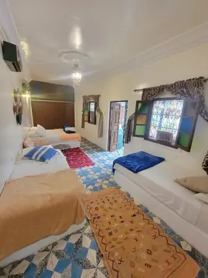 a bedroom with two beds and a window at Dar KAYED in Fès