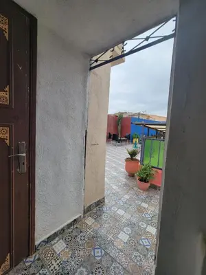 an open door to a courtyard with potted plants at Dar KAYED in Fès