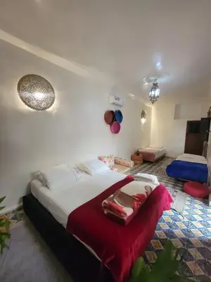 a bedroom with a bed with a red blanket on it at Dar KAYED in Fès