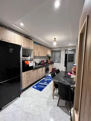 a kitchen with a table and a black refrigerator at Cozy apartment and central location in Meknès