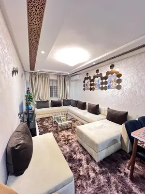 a living room with a couch and a table at Cozy apartment and central location in Meknès