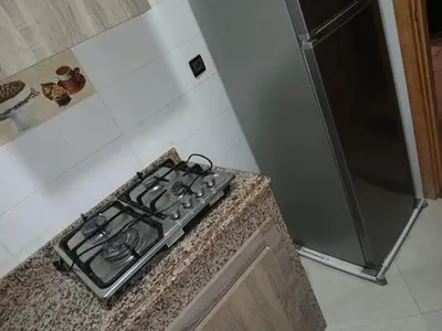 a stove top oven in a kitchen next to a counter at Appartement propre in Fès