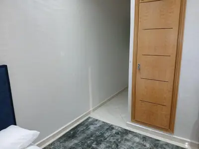 a room with a wooden door and a rug at Appartement propre in Fès