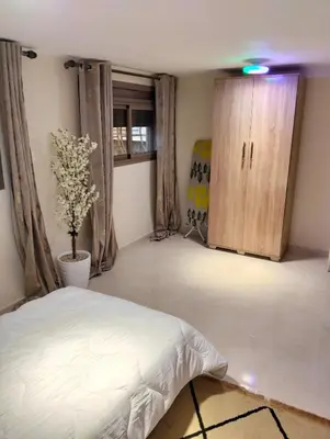 a bedroom with a bed and a wooden cabinet at High-Standing Accommodations - Dalia , Tiflet in Tiflet