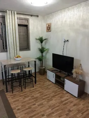 a living room with a table and a flat screen tv at High-Standing Accommodations - Dalia , Tiflet in Tiflet