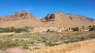 a village in the desert with a mountain in the background at gite traditionnel berbère chez Naima in Lac Yasmins