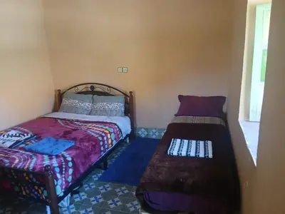 a bedroom with a twin bed and a bed sidx sidx sidx at gite traditionnel berbère chez Naima in Lac Yasmins