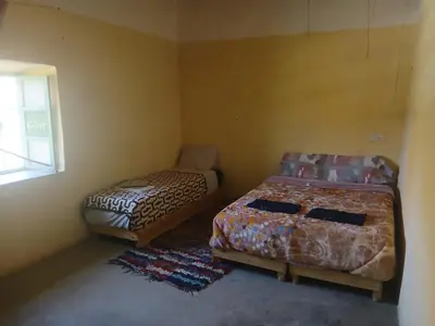 two beds sitting in a room with a window at gite traditionnel berbère chez Naima in Lac Yasmins