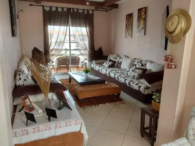 a living room with a couch and a table at Appartement front de mer à Sidi Rahal