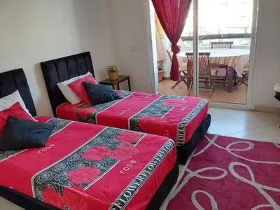 a room with two beds and a room with a balcony at Appartement front de mer à Sidi Rahal