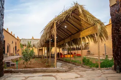 a large straw umbrella in a courtyard with a building at Riad Du Sud in Tamsahelt