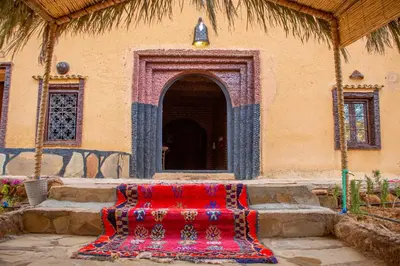 a red rug sitting in front of a building at Riad Du Sud in Tamsahelt