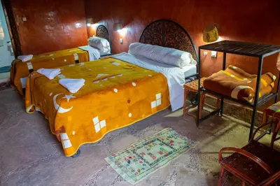a bedroom with two beds and a table at Riad Du Sud in Tamsahelt