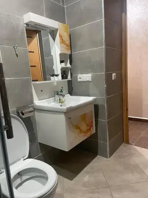 a bathroom with a toilet and a sink and a mirror at large & comfotable apartment close to everything in Meknès