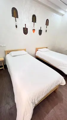 two beds in a room with lights on the wall at large & comfotable apartment close to everything in Meknès