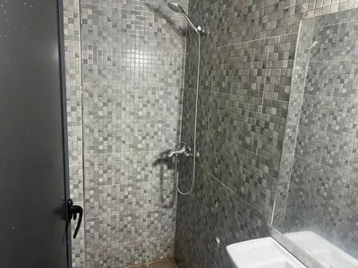a shower with a glass door next to a sink at Luxury University Apartment 3 in Fès