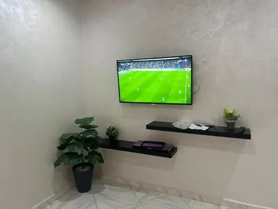 a television on a wall with a soccer game on it at Luxury University Apartment 3 in Fès