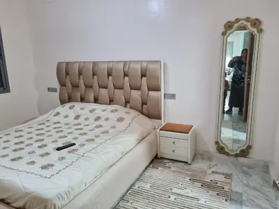 a bedroom with a large bed with a mirror at apparemment in Fès