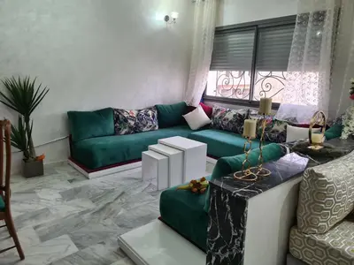 a living room with a green couch and a window at apparemment in Fès