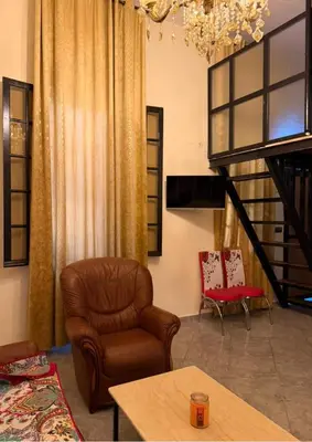 a living room with a leather chair and a staircase at Atlas city fes in Fès