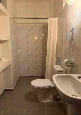 a white bathroom with a toilet and a sink at Atlas city fes in Fès
