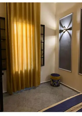 a room with a yellow curtain and a window at Atlas city fes in Fès