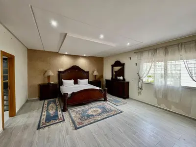 a bedroom with a bed and a large window at Villa Fez Prestige with jacuzzi, Chic & peaceful in Fès