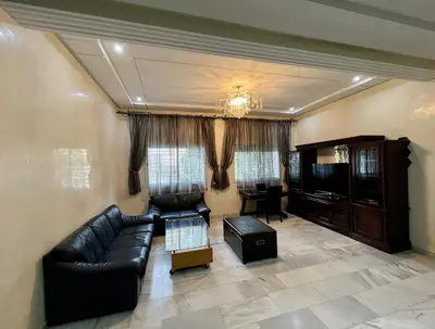 a living room with a black leather couch and a table at Villa Fez Prestige with jacuzzi, Chic & peaceful in Fès