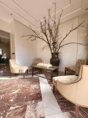a living room with a table and a vase with branches at Ferme des Oliviers - Villa de Charme avec Vue Nature in Sfiani