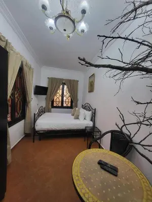 a bedroom with a bed and a table and a window at Ferme des Oliviers - Villa de Charme avec Vue Nature in Sfiani