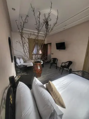 a bedroom with a bed and a living room at Ferme des Oliviers - Villa de Charme avec Vue Nature in Sfiani